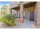 Inviting condo entrance featuring brick pillars, a cozy porch, and well-kept landscaping at 12760 Ironstone Way # 103, Parker, CO 80134