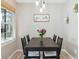 Dining room features modern lighting, seating for six, and a view from large window at 8331 S Upham Way # 101, Littleton, CO 80128