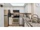Well-lit kitchen with stainless steel appliances, granite countertops, and white cabinets at 8331 S Upham Way # 101, Littleton, CO 80128