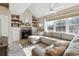Comfortable living room with stone fireplace, built-in shelves, and a large window for ample sunlight at 8331 S Upham Way # 101, Littleton, CO 80128
