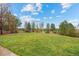 Manicured backyard featuring lush green grass and mature trees, offering a serene outdoor space at 5791 Chisholm Pl, Parker, CO 80134