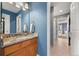 Cozy bathroom featuring granite counters, wood cabinets, and access to additional rooms at 5791 Chisholm Pl, Parker, CO 80134