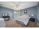 Comfortable bedroom features a white bed, ceiling fan, carpet, and a bright window at 5791 Chisholm Pl, Parker, CO 80134