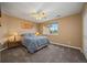 Comfortable bedroom features a queen bed, ceiling fan, carpet, and a bright window at 5791 Chisholm Pl, Parker, CO 80134