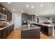 Well-lit kitchen features an island, stainless steel appliances, mosaic backsplash, and beautiful hardwood floors at 5791 Chisholm Pl, Parker, CO 80134