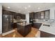 Stylish kitchen featuring dark wood cabinets, stainless steel appliances, and a granite-topped island at 5791 Chisholm Pl, Parker, CO 80134