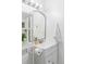 Well-lit bathroom with shelf, towel rack, decorative mirror, and contemporary faucet at 9453 W Utah Pl, Lakewood, CO 80232
