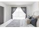 Bedroom featuring large window with grey curtains, allowing for great natural light at 9453 W Utah Pl, Lakewood, CO 80232