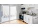 Efficient kitchen layout with stainless steel appliances, white cabinets, and access to outdoor patio at 9453 W Utah Pl, Lakewood, CO 80232