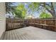 Backyard featuring a wooden deck, a wooden fence, grass, and mature trees at 15942 E Rice Pl # B, Aurora, CO 80015