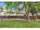 Backyard featuring exterior siding, grass, mature trees, and a wooden fence at 15942 E Rice Pl # B, Aurora, CO 80015
