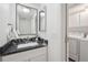 Bathroom features a vanity with granite countertop, framed mirror, and leads to the laundry room at 15942 E Rice Pl # B, Aurora, CO 80015