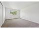 Bright bedroom with neutral carpet, white walls, and natural light from the window at 15942 E Rice Pl # B, Aurora, CO 80015