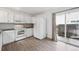 Bright eat-in kitchen with modern appliances, white cabinets, gray flooring, and sliding glass door to backyard at 15942 E Rice Pl # B, Aurora, CO 80015