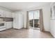 Functional kitchen area with white cabinets, appliances, and sliding doors to the backyard at 15942 E Rice Pl # B, Aurora, CO 80015