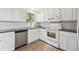 Bright kitchen features white cabinetry, stainless steel sink, modern appliances, and wood-look flooring at 15942 E Rice Pl # B, Aurora, CO 80015