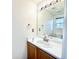 A half bathroom featuring a wood cabinet with white countertops and a large mirror at 2247 Coronado Pkwy N #D, Denver, CO 80229