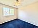 Bedroom with blue carpet and a ceiling fan has great natural light from the large window at 2247 Coronado Pkwy N #D, Denver, CO 80229