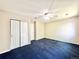 Large bedroom with closet space, neutral walls, blue carpet, and a ceiling fan at 2247 Coronado Pkwy N #D, Denver, CO 80229