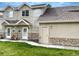 Charming townhome featuring a stone facade, well-maintained lawn, and inviting entrance, offering a welcoming curb appeal at 2247 Coronado Pkwy N #D, Denver, CO 80229