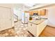 Open-concept kitchen featuring granite countertops, oak cabinets, and tile flooring, seamlessly connecting to the entryway and stairs at 2247 Coronado Pkwy N #D, Denver, CO 80229
