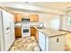 Spacious kitchen with white appliances, oak cabinets, and tile floors, offering functionality and a seamless transition to living spaces at 2247 Coronado Pkwy N #D, Denver, CO 80229