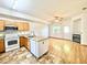 Kitchen with stainless steel sink and oak cabinets opens to a living area with hardwood floors and a modern fireplace at 2247 Coronado Pkwy N #D, Denver, CO 80229