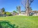 Expansive backyard with mature trees, lush green grass, and a privacy fence, offering ample space at 13133 Regulus Dr, Lone Tree, CO 80124