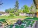 Landscaped backyard with a stone fire pit, a well-maintained lawn, and a privacy fence at 13133 Regulus Dr, Lone Tree, CO 80124