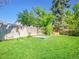 Spacious backyard with lush green grass, a wooden sandbox, and mature trees for shade and privacy at 13133 Regulus Dr, Lone Tree, CO 80124