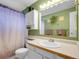 Bathroom with a vanity, mirror, and shower with tub, complemented by green walls and a plant at 13133 Regulus Dr, Lone Tree, CO 80124