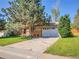 Home with a spacious driveway and a lush green lawn, shaded by a mature tree at 13133 Regulus Dr, Lone Tree, CO 80124