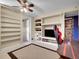 Finished basement game room with ample shelving, carpet flooring, and ceiling fan at 13133 Regulus Dr, Lone Tree, CO 80124