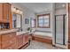 Well-lit bathroom features a bathtub, wooden cabinets, and a separate glass shower at 6839 Estes Dr, Arvada, CO 80004