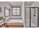 Bright bathroom with a bathtub beside a window and glass shower with detailed tile at 6839 Estes Dr, Arvada, CO 80004