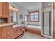 Well-lit bathroom features a bathtub, wooden cabinets, and a separate glass shower at 6839 Estes Dr, Arvada, CO 80004