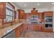 Well-equipped kitchen with wooden cabinets, granite countertops, and modern appliances at 6839 Estes Dr, Arvada, CO 80004