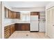 Traditional kitchen with light wood floors, cabinets, white appliances, and laundry hookups at 3298 Quail St, Wheat Ridge, CO 80033