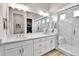Modern bathroom featuring double vanity, marble shower with glass door, and wood-look floors at 1195 Melting Snow Way, Castle Rock, CO 80109