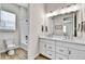 Bright bathroom featuring a double sink vanity, modern fixtures, and a separate shower/tub with a white tile surround at 1195 Melting Snow Way, Castle Rock, CO 80109