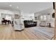 Open-concept living room showcasing hardwood floors, large windows, and seamless flow into the kitchen at 1195 Melting Snow Way, Castle Rock, CO 80109