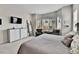 Bright main bedroom featuring TV, bay windows, gray carpet, white dresser, and cozy sitting area at 1195 Melting Snow Way, Castle Rock, CO 80109