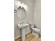 Classic powder room featuring pedestal sink, neutral paint, wood floors, and elongated toilet at 1195 Melting Snow Way, Castle Rock, CO 80109