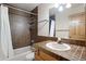 This bathroom features a vanity, mirror, toilet, and shower-tub combo with brown tile backsplash at 1961 S Xenia Ct, Denver, CO 80231