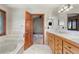 Elegant bathroom featuring double sinks, marble countertops, and a relaxing tub at 1961 S Xenia Ct, Denver, CO 80231