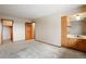 A spacious bedroom with light-colored walls and floors, built-in sink vanity, and multiple doorways at 1961 S Xenia Ct, Denver, CO 80231