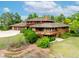 Unique, multi-story home featuring a wood and brick exterior, complemented by mature landscaping at 1961 S Xenia Ct, Denver, CO 80231
