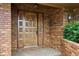 Intricate carved wood front door with brick exterior and classic lantern sconce at 1961 S Xenia Ct, Denver, CO 80231