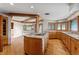 Bright kitchen with hardwood floors, custom cabinetry, a central island cooktop, and open layout at 1961 S Xenia Ct, Denver, CO 80231