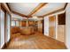 Open-concept kitchen featuring hardwood floors, custom cabinetry, a central island cooktop, and natural wood beam accents at 1961 S Xenia Ct, Denver, CO 80231